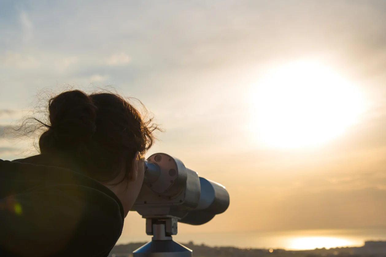 woman looking out of binoculars new perspective
